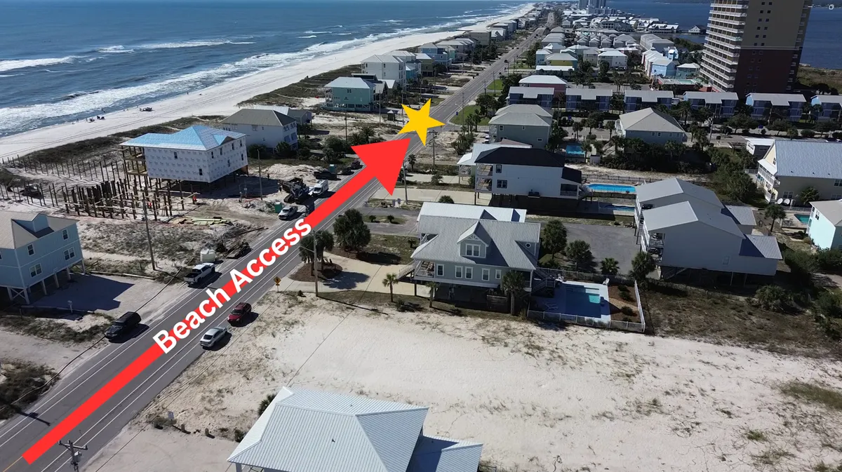 An aerial view shows a stretch of long sandy beach along the Gulf of Mexico, dotted with coastal homes—some with private pools—and a road offering direct access. The property is marked, highlighting its ideal position for exploring both beach and lagoon.